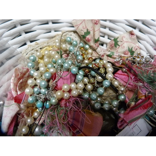 327 - Faux ivory lady's hand mirror, costume brooches, beads etc., contained in a painted wicker basket.