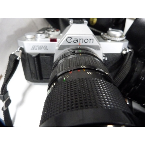 70 - Cameras to include a Canon AV-1 with a Canon lens, Canon ML camera and another, similar, Canon light... 