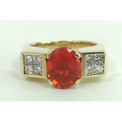 170C - Gold ring with oval fire opal flanked by eight pavé set princess cut diamonds, probably '18k'... 