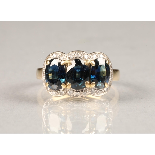 66 - 18 carat gold three stone sapphire ring, surrounded by diamonds. ring size M/N