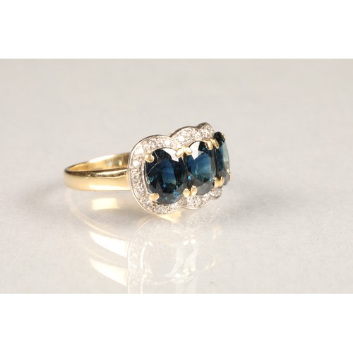 66 - 18 carat gold three stone sapphire ring, surrounded by diamonds. ring size M/N