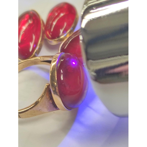 110 - Red amber cabochon ring and a pair of similar cuff links, in gold, 9.7g.