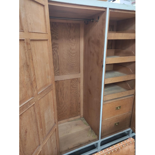 579 - Painted oak triple wardrobe by Heals, the three multi panel doors enclosing drawers, trays and hangi... 