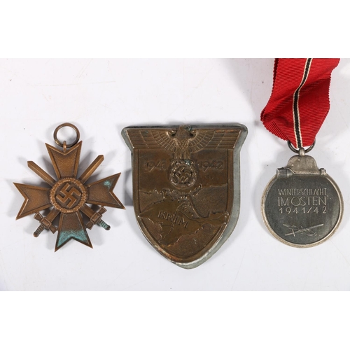 555 - German WWII badges to include a Crimea 'Krim' shield, a 1939 war merit cross and an Eastern medal 19... 