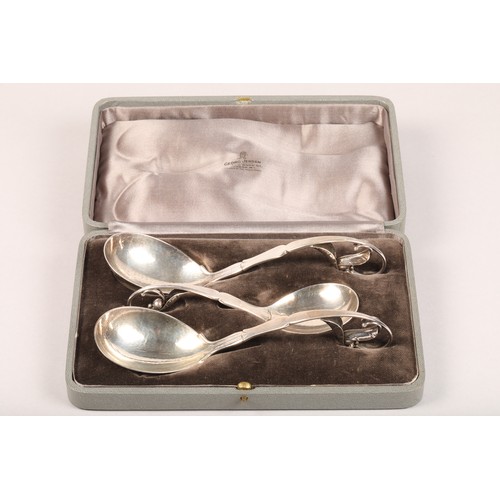 183 - Boxed set of three Georg Jensen Silver serving spoons, with scrolled handles with leaf finials, hamm... 