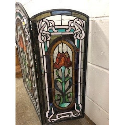 573 - Stained glass triptych folding fire screen, decorated with three stylised panels of flowers, length ... 