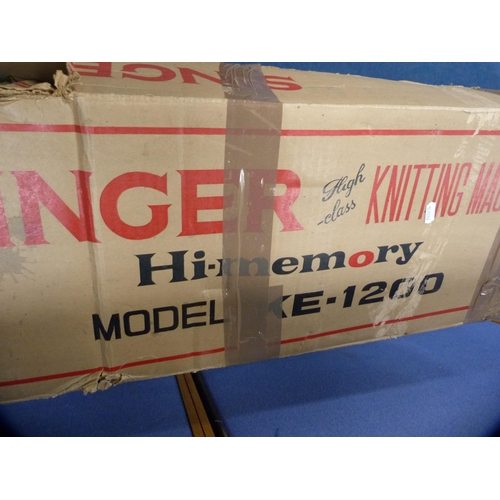 131 - Singer knitting machine, boxed, model KE-1200, on a folding table.