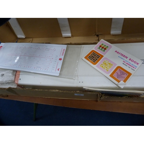 131 - Singer knitting machine, boxed, model KE-1200, on a folding table.