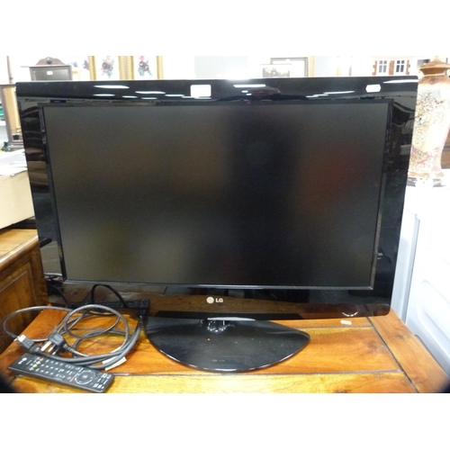 350 - LG television with remote on a wooden TV stand.