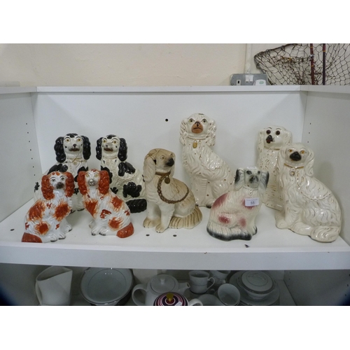 55 - Collection of nine various Staffordshire dogs (one shelf).