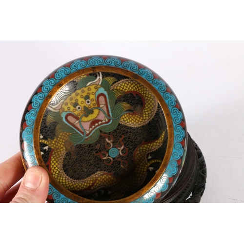 11 - Chinese cloisonné bowl, five claw dragons to sides and well with wooden stand, 14cm diameter.