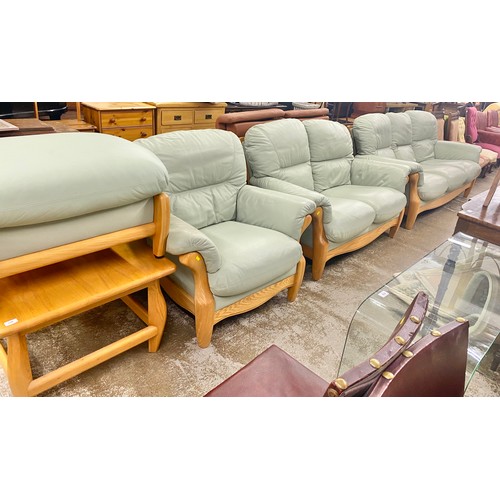 Contemporary pale green leather and beech wood lounge suite comprising a three seater sofa a two se