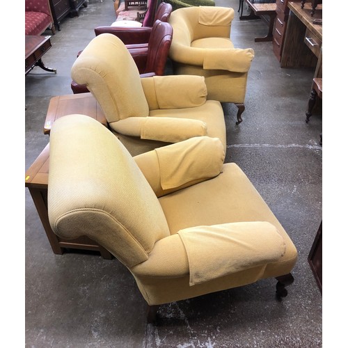 537 - Two armchairs and a two seater sofa, upholstered in lemon fabric, raised on mahogany supports, termi... 