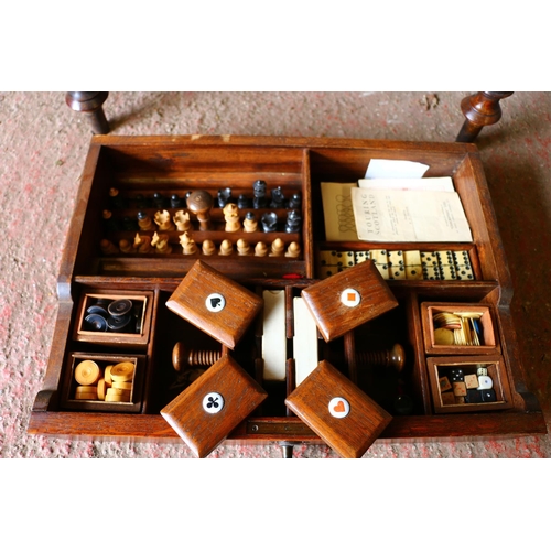 688 - Late 19th century oak games compendium complete with chess set, cards and bone dominos. raised on tr... 