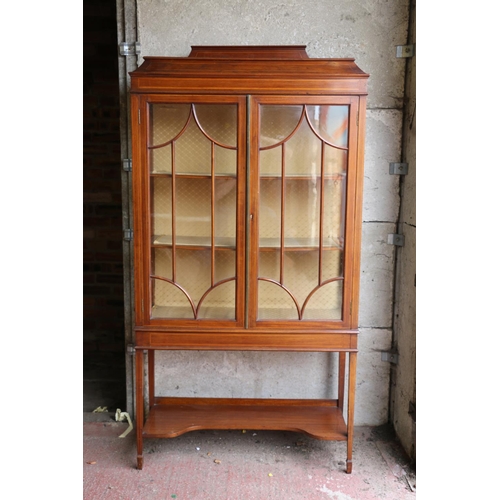 700 - Edwardian mahogany and cross-banded display cabinet, with ledge-back and sarcophagus top, over two g... 