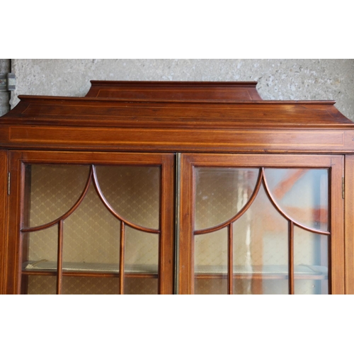 700 - Edwardian mahogany and cross-banded display cabinet, with ledge-back and sarcophagus top, over two g... 