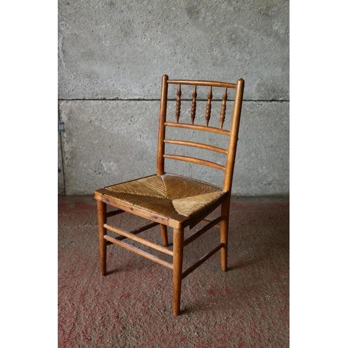 707 - Child's beech chair, with spindle back and rush seat, raised on turned supports, united by stretcher... 