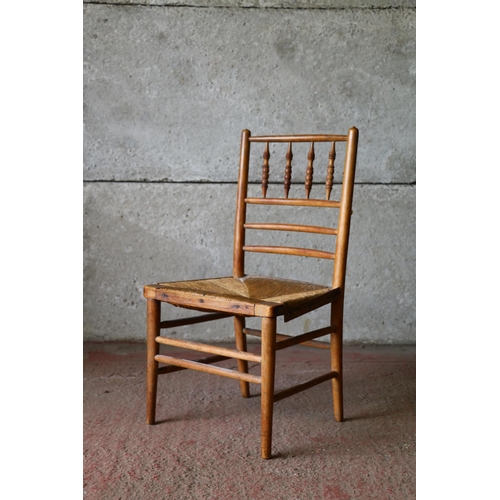 707 - Child's beech chair, with spindle back and rush seat, raised on turned supports, united by stretcher... 