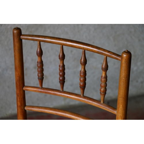 707 - Child's beech chair, with spindle back and rush seat, raised on turned supports, united by stretcher... 