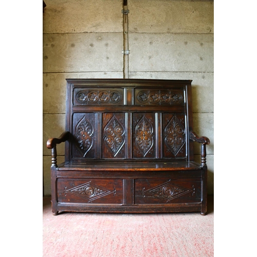 733 - 18th century settle, with panelled carved back, hinged seat over unfitted interior, 136 x 143 x 455c... 