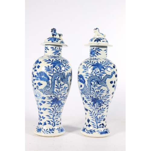 534 - Pair of 19th century Kangxi blue and white baluster shaped lidded vases with guardian dog knops and ... 