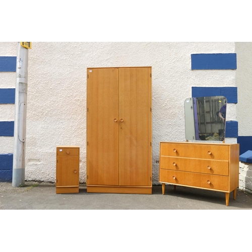 594 - Mid-century oak Meridew four piece bedroom suite comprising a dressing table, a wardrobe, a chest of... 