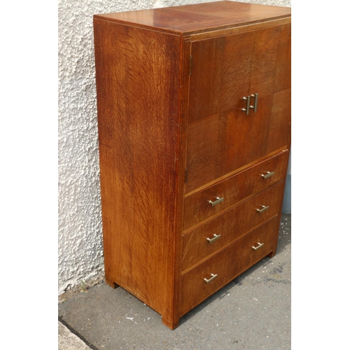 601 - Art Deco limed oak tallboy by Heals of London, the twin-cabinet doors having quarter panel veneer, a... 