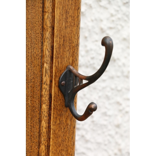 602 - Early 20th century Arts & Crafts oak hallstand, the twin panelled back flanked by six coat hooks... 