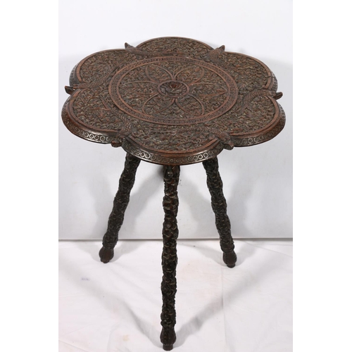 642 - Indian carved table with fish and foliate caved undulating edged top on carved tripod support, 56 x ... 