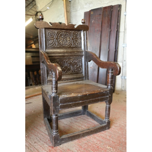 648 - 17th century wainscot chair, the foliate carved panel back with acorn finials, above solid seat, sha... 