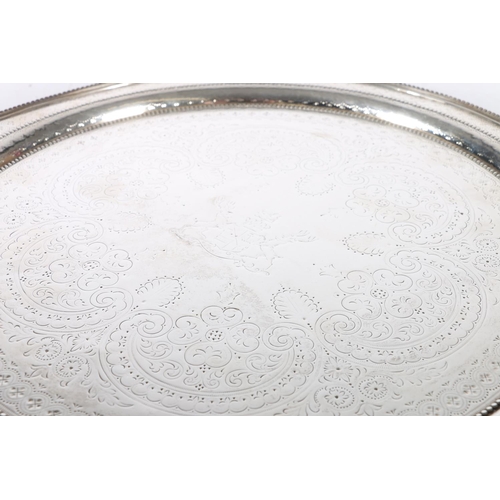 50G - Victorian silver circular salver with beaded edge and bands, incised floral designs, raised on four ... 