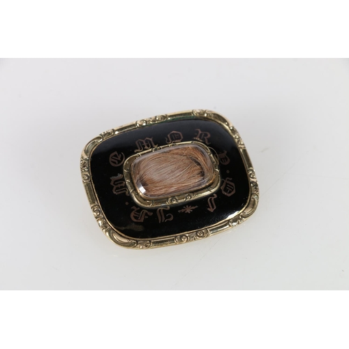 565A - Georgian mourning brooch, with black enamel and hair within beveled glass frame, 4 x 3 cm.