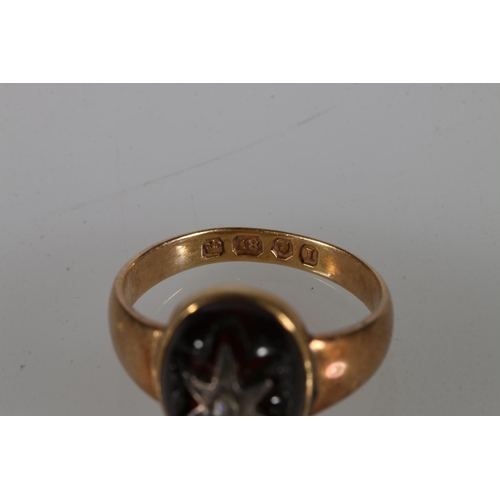 189 - 18ct gold ring with large oval red cabochon stone with star cut hole housing a white metal star with... 