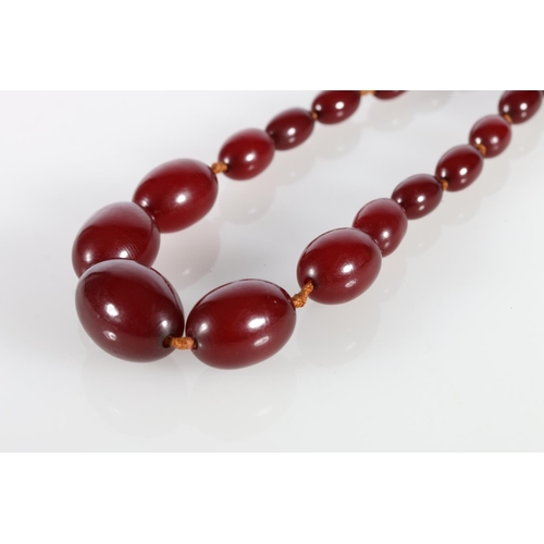 213 - Strand of 21 graduated cherry coloured amber beads, 41.5g gross.