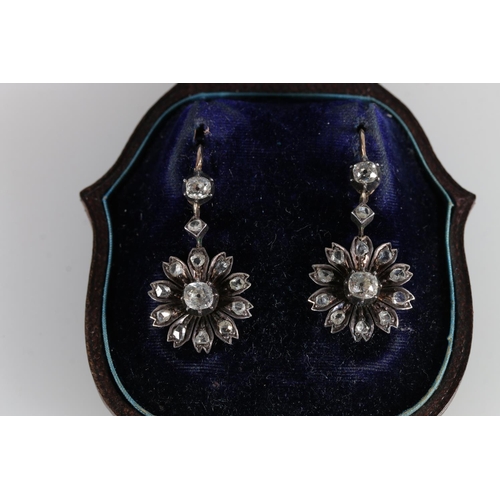 69 - Pair of unhallmarked yellow and white metal earrings in the form of flowers, the central 0.3ct diamo... 