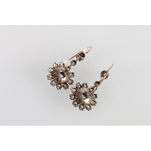 69 - Pair of unhallmarked yellow and white metal earrings in the form of flowers, the central 0.3ct diamo... 