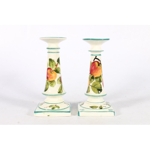 482 - Pair of Wemyss pottery candlesticks with peach design, painted green 'Wemyss' mark to the base, 18cm... 