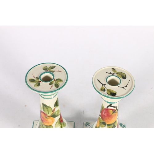 482 - Pair of Wemyss pottery candlesticks with peach design, painted green 'Wemyss' mark to the base, 18cm... 