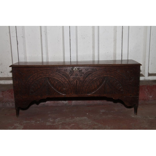 666 - Oak coffer with the hinged lid over interior with candle box, front having carved decoration, raised... 