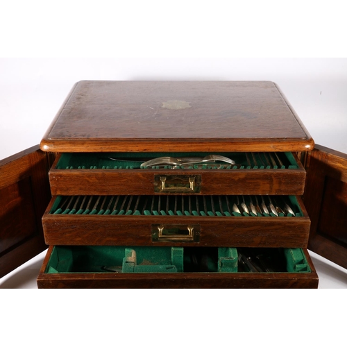 353 - Edwardian Oak cutlery canteen with two panelled doors before three graduated drawers with quantity o... 