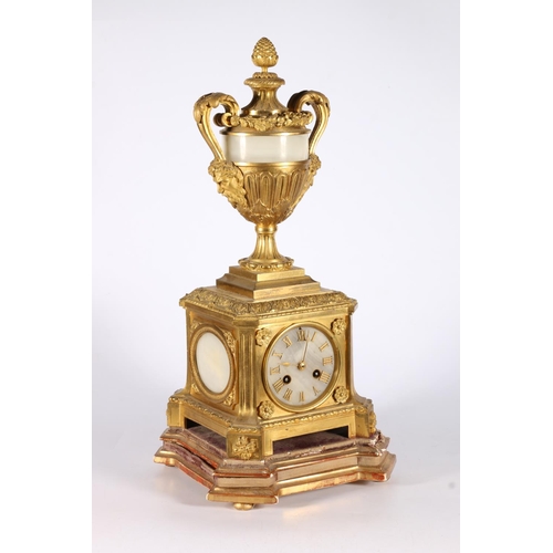 387 - 19th c. clock gilt metal mantle clock with urn finial having stone and two face mask handles to side... 