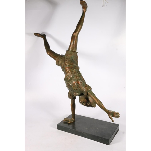 422 - Resin sculpture of child on one hand or performing cartwheel, 84cm