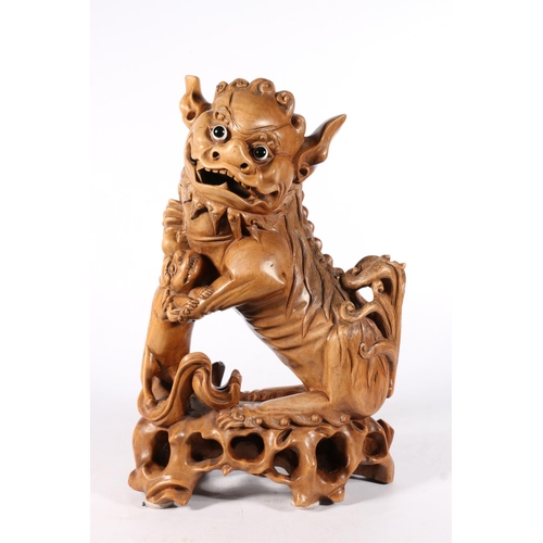 555 - Chinese carved wood fu dog model with glass eyes modelled standing with infant, 39cm tall.