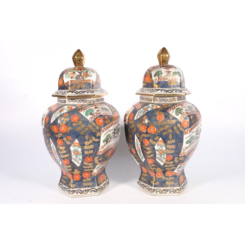 565 - Pair of first half of 20th c. Chinese faceted baluster shaped vases with lids, both with red seal ma... 