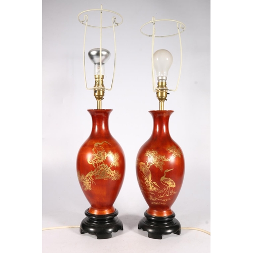 557 - Pair of Japanese papier-mâché baluster shaped table lamps with gilt crane decoration, on wooden stan... 