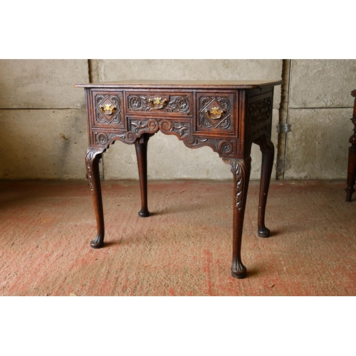 735 - Late 18th/early 19th century oak lowboy, with carved front, raised on cabriole supports terminating ... 