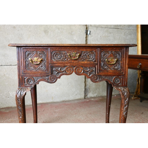 735 - Late 18th/early 19th century oak lowboy, with carved front, raised on cabriole supports terminating ... 