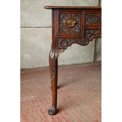 735 - Late 18th/early 19th century oak lowboy, with carved front, raised on cabriole supports terminating ... 