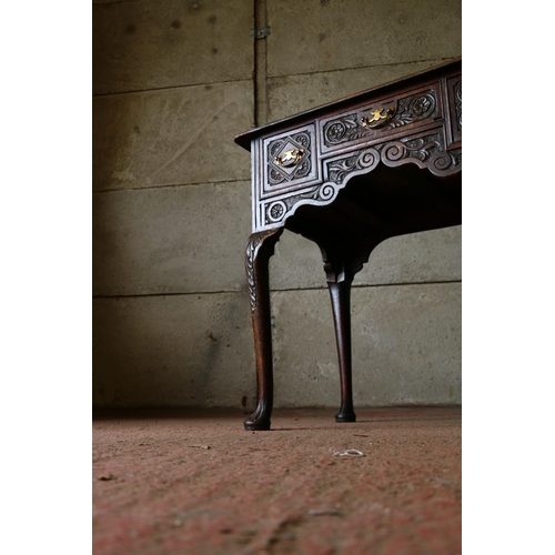 735 - Late 18th/early 19th century oak lowboy, with carved front, raised on cabriole supports terminating ... 