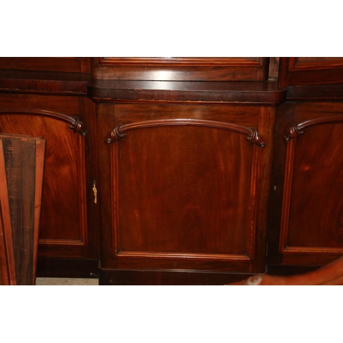 740 - Victorian mahogany bookcase, the inverted break front top with three glazed doors enclosing adjustab... 